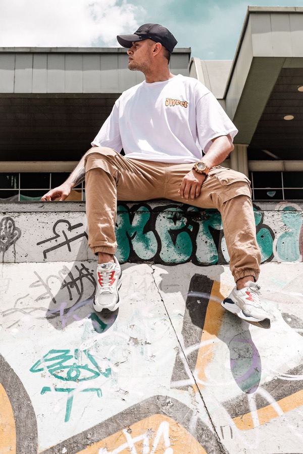 Homme en t-shirt oversize blanc, pantalon cargo camel et casquette