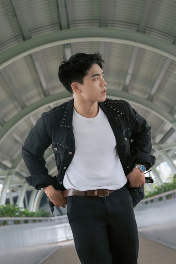 Jeune homme en veste en jean, t-shirt blanc et pantalon foncé